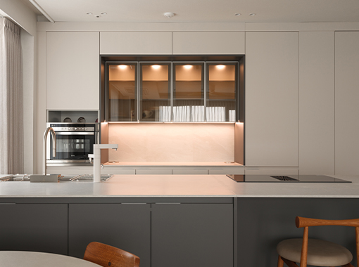 디브릭의 주방 맞춤 인테리어 디자인 사례. 조명으로 포인트를 준 글라스장과 아일랜드 조리대가 돋보이는 모던 주방, 톤온톤으로 구성한 실용적인 주방 설계